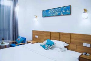 a bedroom with a bed and two blue chairs at Zhangjiajie Tingyutang Little Yard in Zhangjiajie