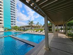 a swimming pool with lounge chairs next to a building at Willow Nest in Bacolod