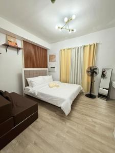 a bedroom with a white bed and a couch at Willow Nest in Bacolod +15 photos