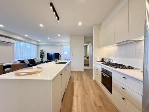 a kitchen with white cabinets and a stove top oven at Aalto Retreat 3 - Chic Modern Close to Everything in Rosebud