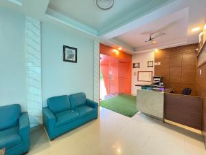 a lobby with two blue chairs and a counter at Lions Den Resort Lonavala in Lonavala