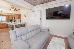 uma sala de estar com um sofá e uma TV de tela plana em 3 Story House 3BR 2BA Rooftop View with Heated Pool em La Choya