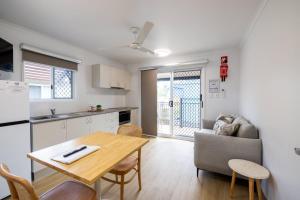 Una cocina y una sala de estar con una mesa y un sofá. en Coral Coast Tourist Park, en Townsville 42 fotos más