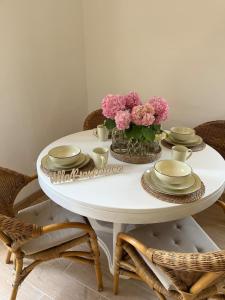 une table blanche avec un vase de fleurs dessus dans l'établissement Villa Biancaluna, à San Felice del Benaco