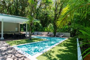 a swimming pool in the middle of a yard with trees at Elan at Ballena Beach in Uvita