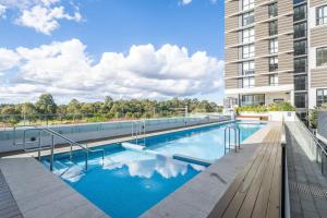 シドニーにあるLuxury studio unit in Macquarie Parkの建物の横にあるプール