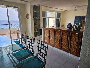 a kitchen with two chairs and a table with a view of the ocean at Cantamar 401, huge condo , incredible views in Cozumel