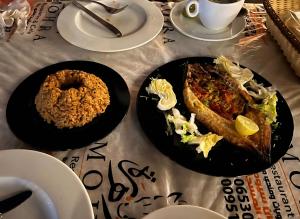 a table with two plates of food on it at Muhra Camp in Siwa