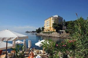 a beach with chairs and umbrellas next to the water at Opatija Apartment in Opatija