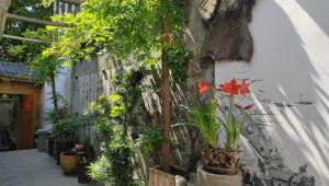 a wall with plants and flowers on it at Zhangjiajie Tingyutang Little Yard in Zhangjiajie