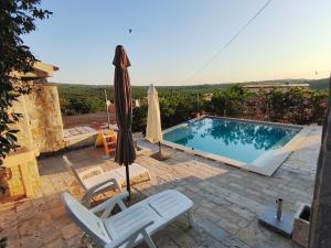 een zwembad met twee stoelen en een parasol bij Villa Mirta in Široke