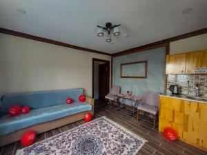 a living room with a blue couch and a table at Danzot Tatil Köyü ve Restoran in Artvin