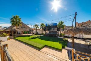 einen Rasen vor einem Gebäude mit Palmen in der Unterkunft 3 Story House 3BR 2BA Rooftop View with Heated Pool in La Choya