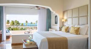 Un dormitorio con una cama con vista al mar. en Excellence Riviera Cancun All Inclusive - Adults Only, en Puerto Morelos