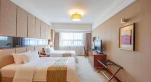 a hotel room with two beds and a television at Jinan Blue Horizon Hotel Shizhong in Jinan