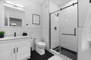 a bathroom with a toilet and a glass shower at Charming 3bed Mill | Gym | Trail in Greenville