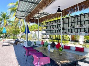 eine Bibliothek mit einem Holztisch und rosa Stühlen in der Unterkunft The Living Pool Villas in Ban Ko Khwan