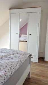 a bedroom with a bed and a mirrored cabinet at Ferienwohnung Shepherd in Remagen