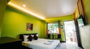 a bedroom with a bed in a room with green walls at Phoem Phoon 2 Hotel in Nan