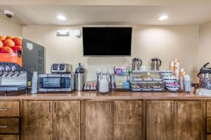 a kitchen with a counter with a tv on the wall at Rodeway Inn & Suites in Tupelo +11 photos