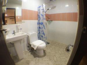 a bathroom with a toilet and a sink and a shower at Horizon Hotel in Olongapo +111 photos