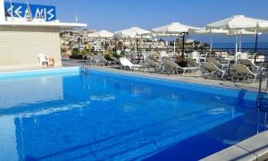 a large swimming pool with chairs and umbrellas at Oceanis Hotel in Kavála