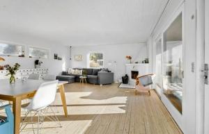 un salon blanc avec une table et des chaises dans l'établissement Holiday Home With Garden Near Tisvilde Beach, à Græsted
