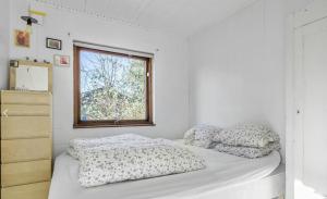 - une chambre avec 2 lits avec des oreillers et une fenêtre dans l'établissement Holiday Home With Garden Near Tisvilde Beach, à Græsted