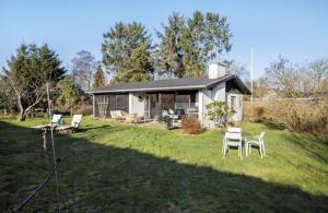 un groupe de chaises assises dans la cour d'une maison dans l'établissement Holiday Home With Garden Near Tisvilde Beach, à Græsted