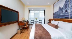 Habitación de hotel con cama grande y TV de pantalla plana. en James Joyce Coffetel Wuhan Huanlegu Renhe Road Subway Station, en Wuhan 9 fotos más