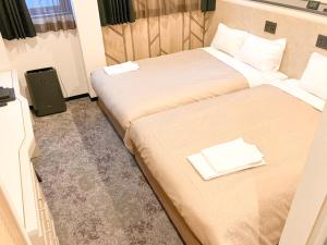 a hotel room with two beds and a television at Hotel LiVEMAX Tendo in Tendo +38 photos