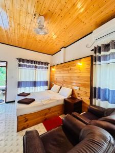 una camera d'albergo con un letto e un divano di Rekawa Turtle Gate Hotel a Tangalle