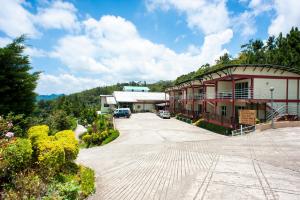 a building with a parking lot in front of it at Celyn Resort Kinabalu in Kundasang