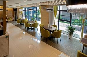 a dining room with tables and yellow chairs at Jinjiang Inn Select Xi'an Dayan Tower Zhuque Street Chengshi Lifang in Xi'an
