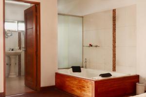 un bagno con vasca e lavandino di Hotel Portobelo Guatape a Guatapé