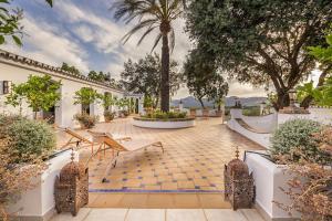 un patio con mesa, sillas y árboles en Ronda Oasis, en La Cimada