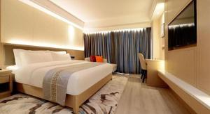 une chambre d'hôtel avec un grand lit et une télévision dans l'établissement Borrman Hotel Guiyang Guanshanhu International Conference Center Metro Station, à Jinzhuzhen