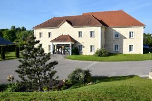 a large white house with a large driveway at Logis Des Sources in Créney-près-Troyes