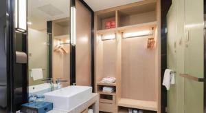 a bathroom with a sink and a mirror at Echarm Hotel Liuzhou Liunan Wanda Plaza in Liuzhou +115 photos