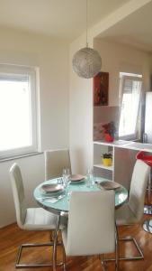 jadalnia z niebieskim stołem i białymi krzesłami w obiekcie Apartment Katarina w mieście Kaštela