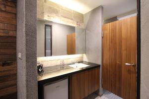 um banheiro com uma pia e um espelho em MZ 1090 B&B em Hengchun South Gate