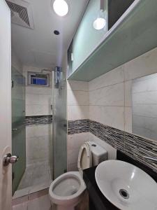 a bathroom with a sink and a toilet and a shower at Andengs Cozy place in Manila