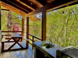 a screened in porch with a sink and a table at Mazamitla - Cabaña Opalo con jacuzzi in Mazamitla
