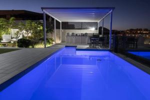 a swimming pool with blue lighting in a house at Heaven Ocin in Telde