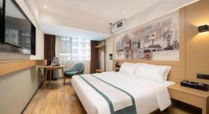 a hotel room with a large bed and a desk at City Comfort Inn Nanning Nanhu Park Art College in Nanning