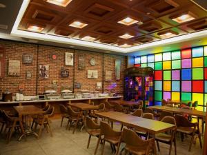 a restaurant with tables and chairs and a stained glass wall at James Joyce Coffetel Shijiazhuang Wanda Plaza Tangu Metro Station in Shijiazhuang