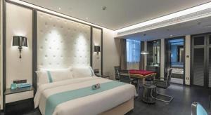 - une chambre avec un grand lit blanc et un bureau dans l'établissement Xana Hotelle Nanchang Hongdu Middle Avenue Provincial TV Station, à Nanchang County 278 autres photos