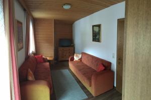 a living room with two red couches and a television at Garni Fischer in Oetz