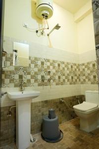 ein Badezimmer mit Waschbecken und Toilette in der Unterkunft G SQUARE Rooms in Rūpnagar