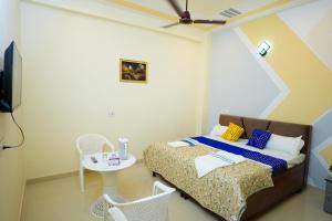 a bedroom with a bed and a table and chairs at G SQUARE Rooms in Rūpnagar